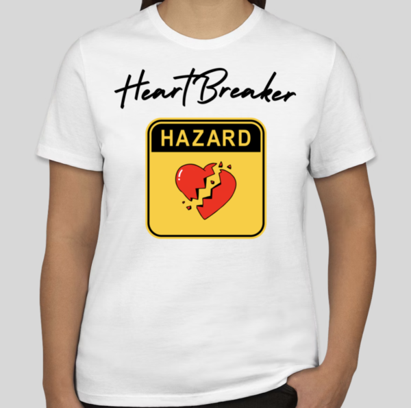 The Heart Breaker t-shirt features the phrase heart breaker written in cursive script. Underneath the script is a hazard symbol with the BHS heart in the middle of the hazard sign. The slim BHS logo has been applied to the back of the t-shirt.