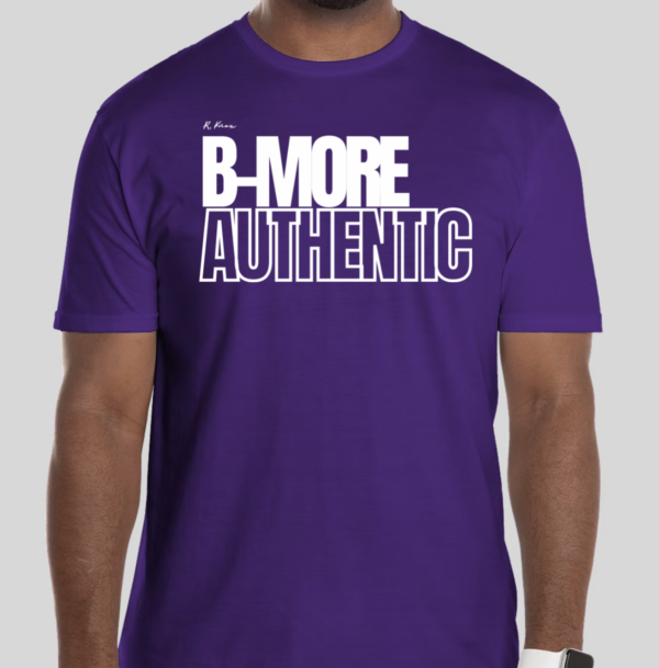 The B-More Authentic t-shirt features boxed text which spells out an abbreviated version of the word Baltimore. An altered version of the BHS logo is applied to the back of the t-shirt.