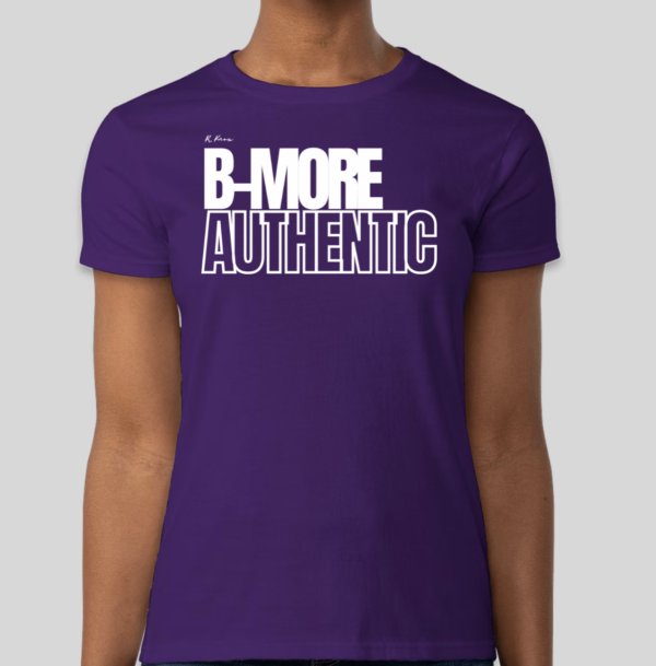 The B-More Authentic t-shirt features boxed text which spells out an abbreviated version of the word Baltimore. An altered version of the BHS logo is applied to the back of the t-shirt.